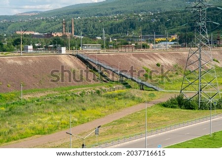 Electric pole against the background of the railway. Power lines along railway tracks. Power supply of railway transport facilities.
