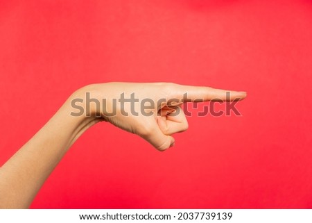 Hand making sign, sign language, red background.