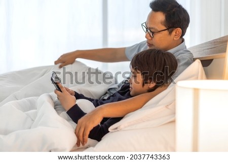 Portrait of enjoy happy love asian family father and little asian boy son smiling playing and having fun teach use tablet watching cartoon and play game at home