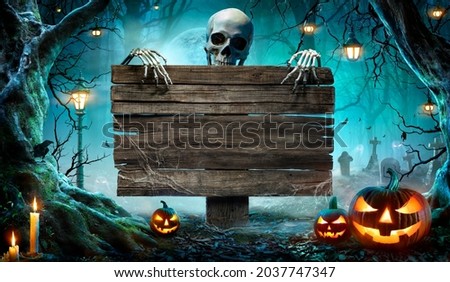 Halloween Party Card - Pumpkins And Skeleton In Graveyard At Night With Wooden Board  Royalty-Free Stock Photo #2037747347