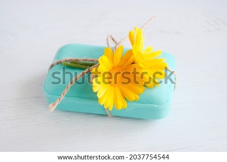 Natural green soap with calendula flowers. Concept of a spa salon. Natural medical cosmetology. Light background. Copy space
