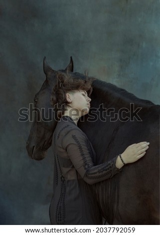 Art portrait of a girl with a horse. A photo as a poster, a picture in the interior. The girl leans against the horse's muzzle and gently hugs her. Image with selective focus and noise effect, toning