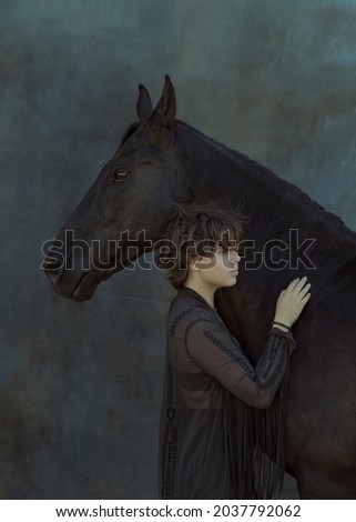 Art portrait of a girl with a horse. A photo as a poster, a picture in the interior. The girl leans against the horse's muzzle and gently hugs her. Image with selective focus and noise effect, toning