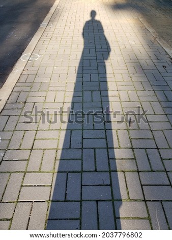 A long shadow on the sidewalk