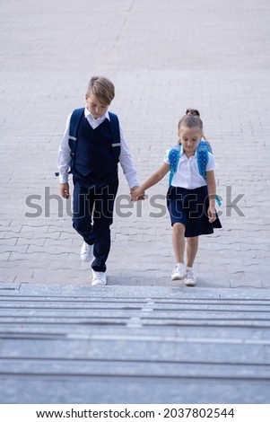 The older brother takes his younger sister to school Royalty-Free Stock Photo #2037802544