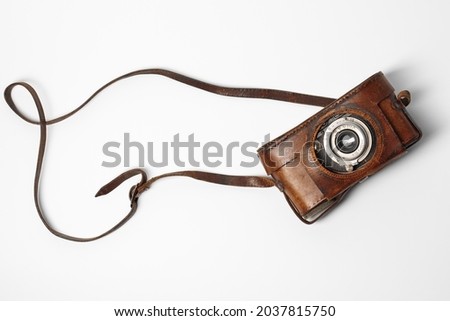 Old vintage camera with 35mm lens in brown leather case isolated on white background Royalty-Free Stock Photo #2037815750