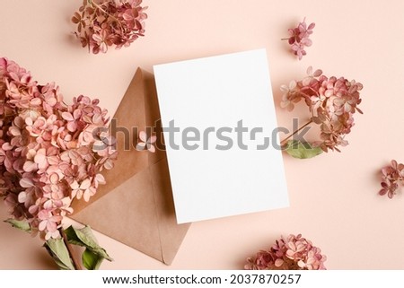 Wedding invitation card mockup with envelope and pink hydrangea flowers decorations.