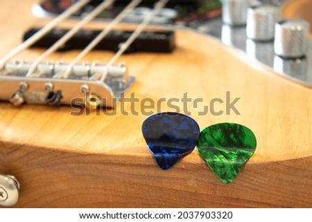 blue and green guitar pick as if they were sitting on a bass