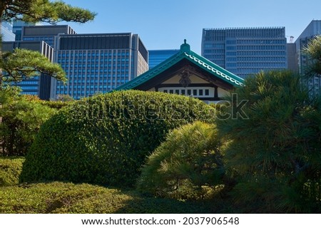 Skyscrapers of Marunouchi commercial and financial district, viewed from Imperial Palace gardens with the traditional japanese building on the foreground. Tokyo. Japan