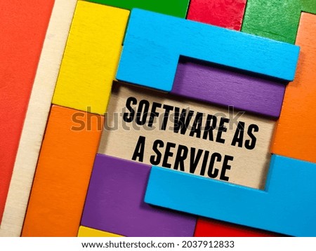 Business concept.Text SOFTWARE AS A SERVICE with wooden puzzle on red background.
