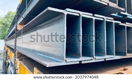 Steel beams production. Metal girders stack on project construction blueprints background, copy space.  Royalty-Free Stock Photo #2037974048
