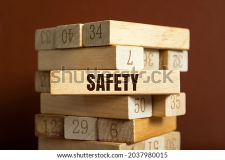 Modern business buzzword - safety. Word on wooden blocks on a brown background. Close up.