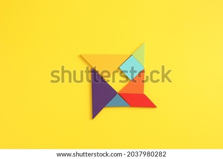 Wooden blocks windmill isolated in yellow background