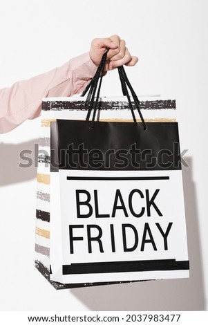 Close-up of shopper holding shopping bags during Black Friday in the store
