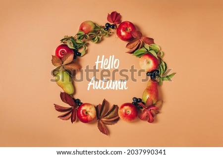 Autumn seasonal fruits apples pears grapes fallen leaves lined with frame pastel background, with phrase Hello Autumn