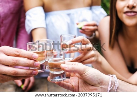 tequila shot, Group of Young latin Friends Meeting For tequila shot or mezcal drinks making A Toast In Restaurant terrace in Mexico Latin America Royalty-Free Stock Photo #2037995171