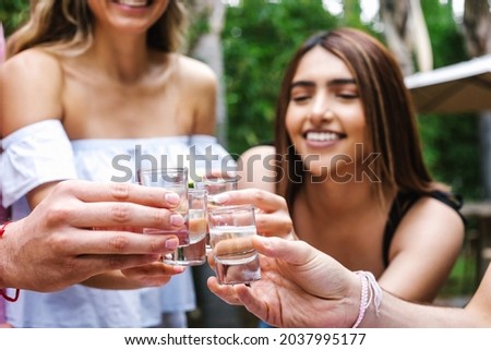 tequila shot, Group of Young latin Friends Meeting For tequila shot or mezcal drinks making A Toast In Restaurant terrace in Mexico Latin America Royalty-Free Stock Photo #2037995177