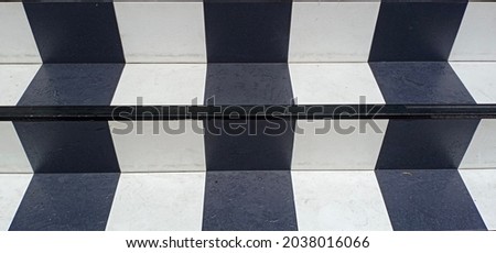 Part of the stairs which are interspersed with white and black square tiles.