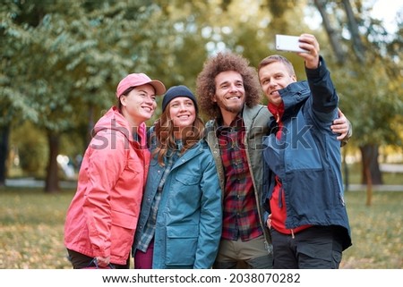 Holidays with friends. Group of young people taking selfie together in the park.