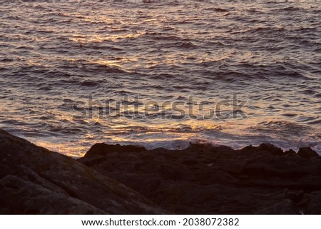 Blue sea and rocky coast at sunset during the summer season. Clear day, blue sky