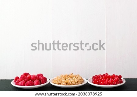 Fresh summer berries in vintage mug over black background, top view