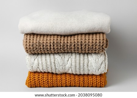 Stack of stylish clothes on grey background