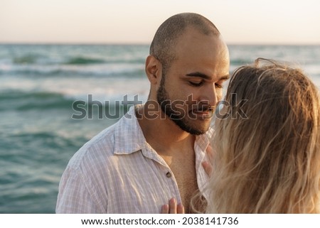 Portrait of happy young couple in love embracing each other on beach