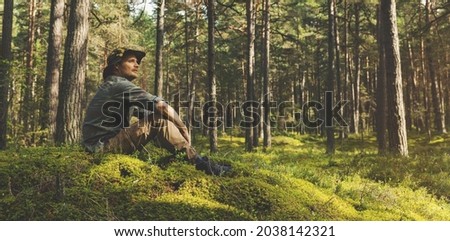 forest ranger or forester sitting on the hill and watching the territory. copy space Royalty-Free Stock Photo #2038142321