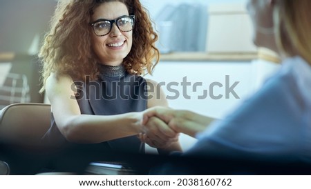 Women are shaking hands in office