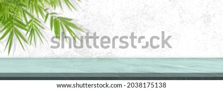 White marble tablet on abstract blur leaves background, panoramic banner - can be used for display or montage your products