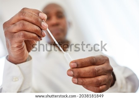 Man makes a Covid-19 diagnostic rapid test as an antigen test at home with a saliva sample