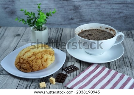 A closeup of a pastry and a cup of hot chocolate on the table in a cafe