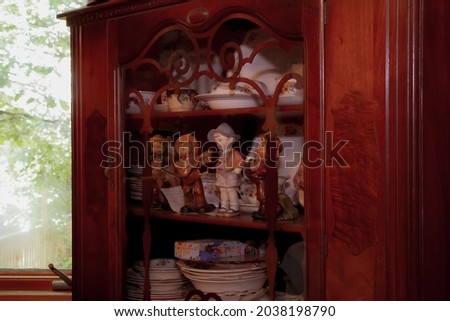 A closeup shot porcelain figurines and chine in a classic-style cabinet Royalty-Free Stock Photo #2038198790