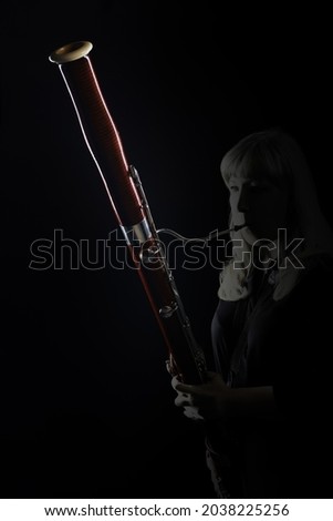 Bassoon woodwind instrument player. Classical musician woman playing orchestral bass. Wind instruments Royalty-Free Stock Photo #2038225256
