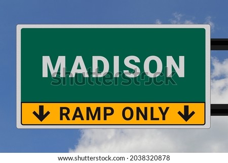 Madison logo. Madison lettering on a road sign. Signpost at entrance to Madison, USA. Green pointer in American style. Road sign in the United States of America. Sky in background
