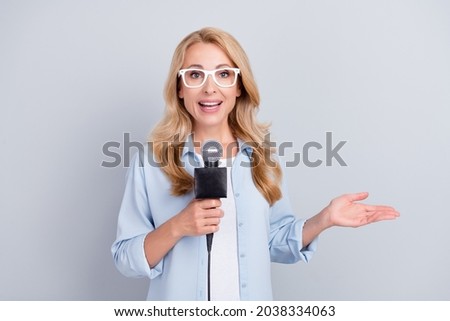 Photo of popular correspondent hold mic talk speak tell news wear specs blue shirt isolated grey color background