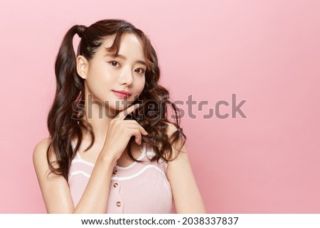 Pink background portrait of a young Asian woman with pigtails Royalty-Free Stock Photo #2038337837