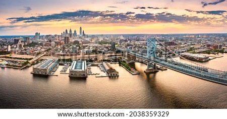 Aerial panorama with Ben Franklin Bridge and Philadelphia skyline at sunset. Ben Franklin Bridge is a suspension bridge connecting Philadelphia and Camden, NJ.