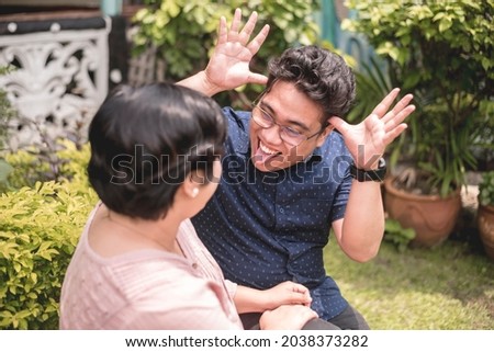 A silly filipino man teases his wife by sticking out his tongue. A fun relationship enjoying laughs and joking around. Royalty-Free Stock Photo #2038373282