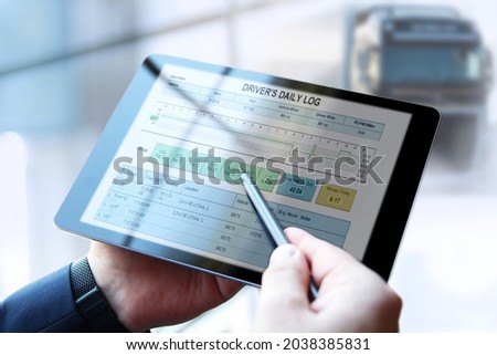 Safety manager is showing to Truck driver  th  electronic logbooks on a tablet Royalty-Free Stock Photo #2038385831