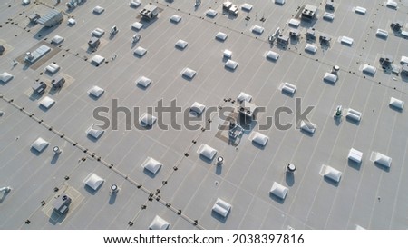 Aerial view of skylights and HVAC equipment on top of a commercial roof building Royalty-Free Stock Photo #2038397816