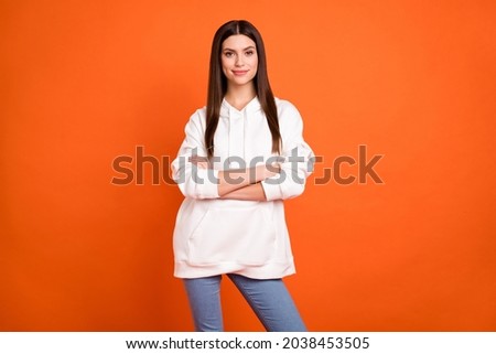 Portrait of attractive cheerful content brunette girl folded arms posing isolated over bright orange color background