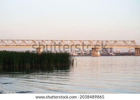 Beautiful railway bridge on the background of the bay at sunset