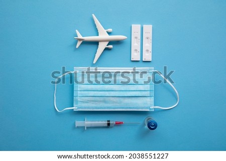 Covid air travel background. Airplane with a coronavirus protective face mask vaccine needle and test.