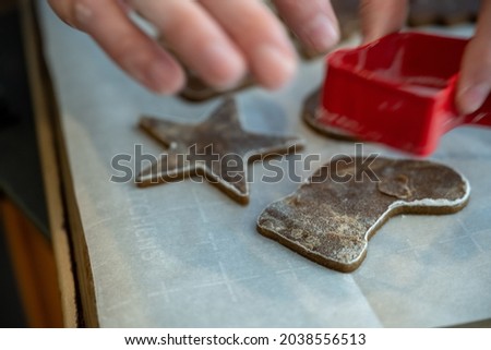Placing Gingerbread Cutout Cookies onto Baking Sheet with parchment paper