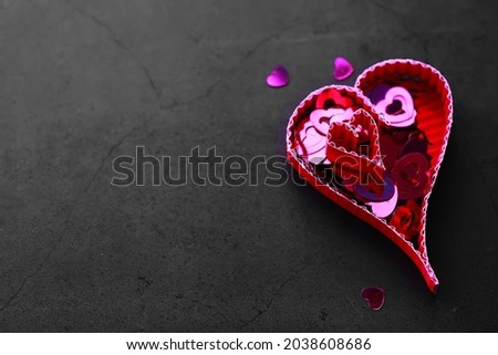 Paper elements in shape of heart on dark stone background. Love and Valentine's day concept. Birthday greeting card design.
