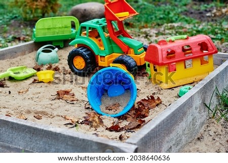 Forgotten toys in the sandbox outside. Children playground outdoors