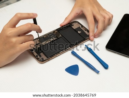 technician replaces the battery of a cell phone or smartphone