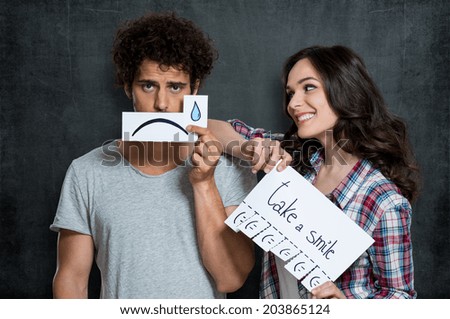 Happy Woman Looking At Man Holding Paper With Tears Drawn On It