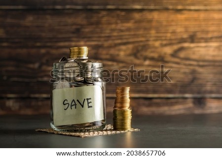 Savings glass bottle on wooden table. Save money, accumulate, savings, wealth and finance concept, business, finance, investment, financial planning and stocks, future.